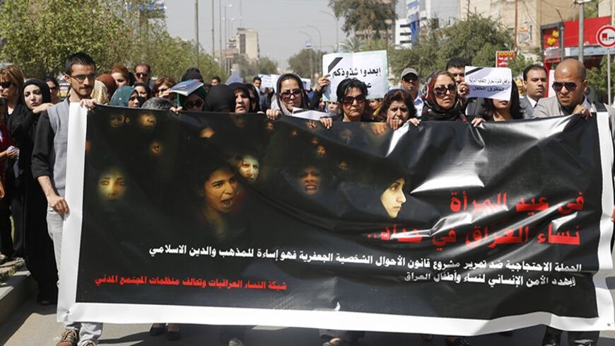 Iraqi Protesters hold a banner during a demonstration against the draft of the "Al-Jafaari" Personal Status Law during International Women's Day in Baghdad March 8, 2014. Protesters say the law, which involves the use of Shi'ite Jafaari law with regards to divorce, marriage and inheritance, will restrict their personal rights, according to local media. On March 8 activists around the globe celebrate International Women's Day, which dates back to the beginning of the 20th Century and has been observed by the
