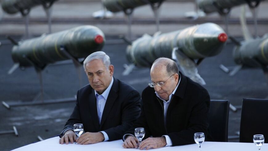 Israel's Prime Minister Benjamin Netanyahu (L) and Defense Minister Moshe Yaalon sit in front of a display of M302 rockets, found aboard the Klos C ship, at a navy base in the Red Sea resort city of Eilat March 10, 2014. Netanyahu, displaying on Monday what Israel said were seized Iranian-supplied missiles bound for militants in Gaza, called on the West not to be fooled by Tehran's diplomatic outreach over its nuclear programme. REUTERS/Amir Cohen (ISRAEL - Tags: POLITICS MILITARY CIVIL UNREST) - RTR3GGUG