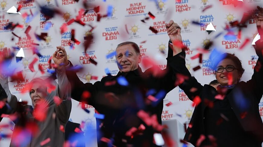 Turkish Prime Minister Tayyip Erdogan (C), accompanied by his wife Emine Erdogan (L) and Maltepe mayoral candidate Edibe Sozen Yavuz, greets his supporters during an election rally of his ruling AK Party in Istanbul March 29, 2014. Turkey has started an espionage investigation after a discussion between top officials on potential military action in Syria was leaked on YouTube, heralding a possible government crackdown on its political opponents after elections on Sunday. The recording of the meeting between