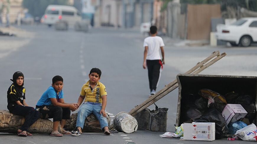 Children sit on a roadblock set up by protesters to prevent riot police from entering the village of Shakhoora, west of Manama, August 14, 2013. Bahraini police fired tear gas and birdshot at demonstrators on Wednesday, witnesses said, as protests called for by activists to press demands for democratic change in the U.S.-allied Gulf kingdom turned violent. REUTERS/Hamad I Mohammed (BAHRAIN - Tags: POLITICS CIVIL UNREST) - RTX12LBN