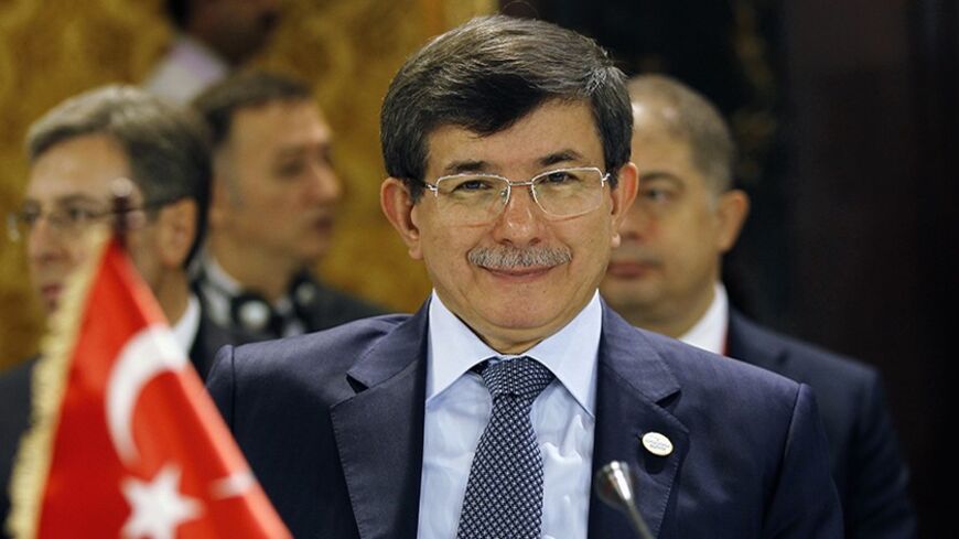 Turkish Foreign Minister Ahmet Davutoglu smiles at photographers during the 12th Asia Cooperation Dialogue Ministerial Meeting in Manama November 25, 2013. REUTERS/Hamad I Mohammed (BAHRAIN - Tags: POLITICS) - RTX15SAF