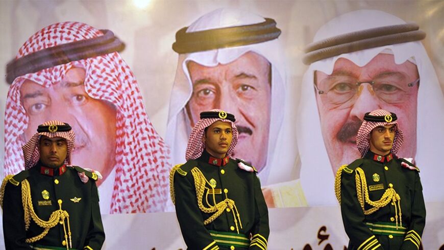 Saudi royal guards stand on duty in front of portraits of King Abdullah bin Abdulaziz (R), Crown Prince Salman bin Abdulaziz (C) and second deputy Prime Minister Muqrin bin Abdulaziz during the traditional Saudi dance known as "Arda" at the Janadriya culture festival at Der'iya in Riyadh, February 18, 2014. REUTERS/Fayez Nureldine/Pool (SAUDI ARABIA - Tags: POLITICS ROYALS) - RTX192TG