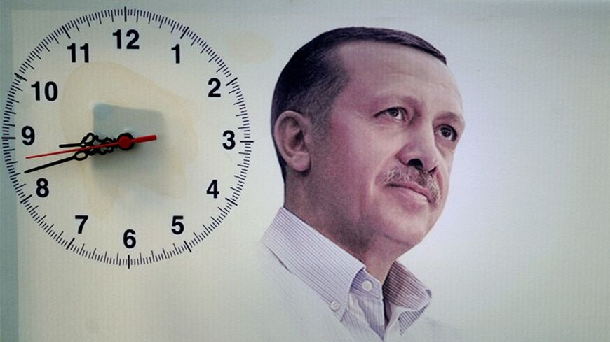 A poster showing Turkish Prime Minister Recep Tayyip Erdogan is seen next to a hanging clock during a rally of the Justice and Development Party (AKP) in the Maltepe district at the asia side of Istanbul on March 29, 2014. Turkey gears up for local elections on March 30 ahead of a presidential vote in six months and parliamentary polls next year. Erdogan and his Islamic-leaning party, after over a decade in power, face the first electoral test following months of political turmoil, with mass street protests