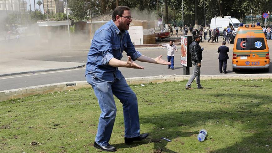 A plainclothes policeman shouts after an explosion, which was followed by two further blasts, in front of Cairo University April 2, 2014. A series of explosions outside Cairo University killed two people on Wednesday, including a police brigadier-general, security officials said, in what appeared to be the latest militant attack in a fast-growing insurgency. REUTERS/Amr Abdallah Dalsh (EGYPT - Tags: POLITICS CIVIL UNREST) - RTR3JNLM