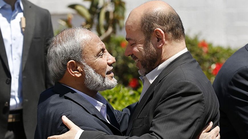 Senior Hamas leader Moussa Abu Marzouk (R) hugs senior Hamas leader Mahmoud Al-Zahar in Gaza City April 21, 2014. Abu Marzouk arrived at the Hamas-controlled Gaza Strip on Monday to take part in unity talks with rival Fatah movement of President Mahmoud Abbas, which are planned for Tuesday, Hamas officials said. REUTERS/Mohammed Salem (GAZA - Tags: POLITICS TPX IMAGES OF THE DAY) - RTR3M230