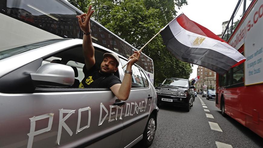 Supporters of deposed President Mohamed Mursi demonstrate as they slow drive through central London August 17, 2013. Supporters of Mursi fought a gunbattle with security forces in a Cairo mosque on Saturday, while Egypt's army-backed government, facing deepening chaos, considered banning his Muslim Brotherhood group.  REUTERS/Luke MacGregor (BRITAIN - Tags: CIVIL UNREST POLITICS RELIGION) - RTX12OXK