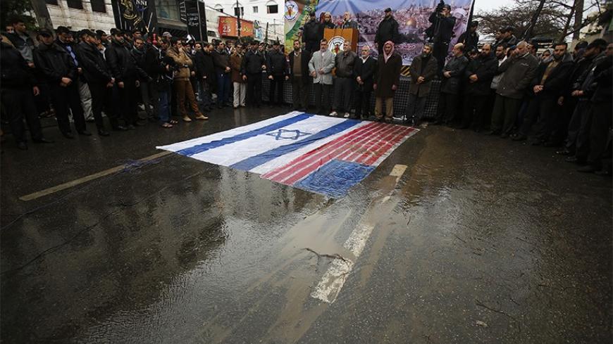 Palestinian Islamic Jihad supporters take part in a protest against U.S.-brokered peace talks between Israel and Palestinians as the U.S. and Israel flags are seen on the ground, in Gaza City January 10, 2014. REUTERS/Suhaib Salem (GAZA - Tags: POLITICS CIVIL UNREST) - RTX178KN