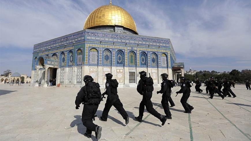 Israeli policemen run in front of the Dome of the Rock during clashes with stone-throwing Palestinians after Friday prayers on the compound known to Muslims as Noble Sanctuary and to Jews as Temple Mount in Jerusalem's Old City February 7, 2014. Israeli police stormed the compound on Friday using stun grenades to disperse Palestinians, some of whom were masked, after they threw stones towards the Western Wall and Mugrabi Gate, no injuries were reported at the scene and 5 Palestinians were detained, a police