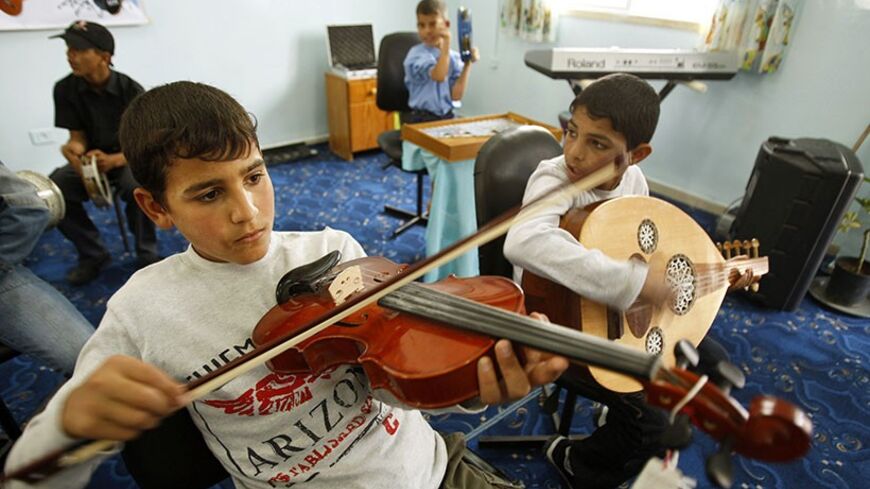 Palestinian orphans play musical instruments at their orphanage in Rafah in the southern Gaza Strip April 23, 2009. REUTERS/Ibraheem Abu Mustafa (GAZA SOCIETY) - RTXEA92
