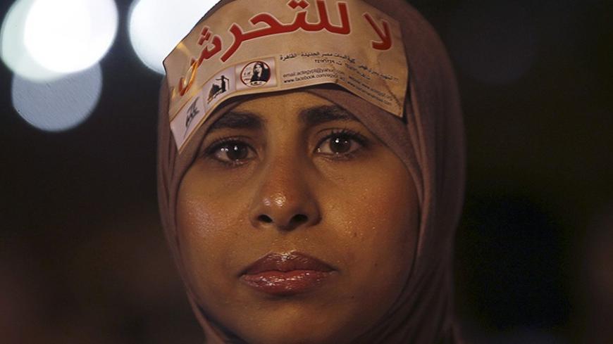 A woman wearing a sign on her head that reads "No Harassment" takes part in a protest against Egypt's President Mohamed Mursi and the Muslim Brotherhood  and in support of women rights in the constitution in front of the presidential palace in Cairo October 4, 2012.  REUTERS/Amr Abdallah Dalsh  (EGYPT - Tags: POLITICS CIVIL UNREST) - RTR38T3N