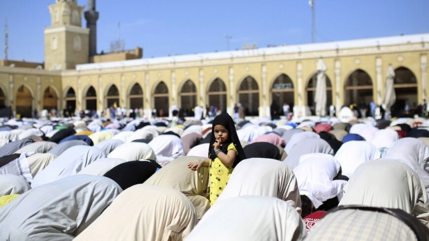 A girl stands amidst people attending Friday prayer in Najaf, south of Baghdad, March 28, 2014.  REUTERS/ Ahmad Mousa (IRAQ - Tags: RELIGION TPX IMAGES OF THE DAY) - RTR3J081