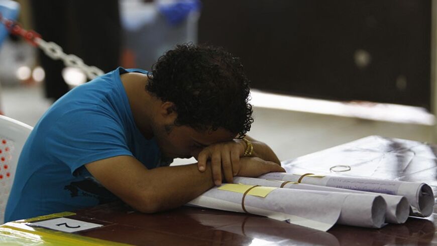 A member of the Independent High Electoral Commission (IHEC) sleeps during a vote counting session for the parliamentary election at an analysis centre in Baghdad May 11, 2014. REUTERS/Ahmed Saad (IRAQ - Tags: POLITICS ELECTIONS) - RTR3ON4B