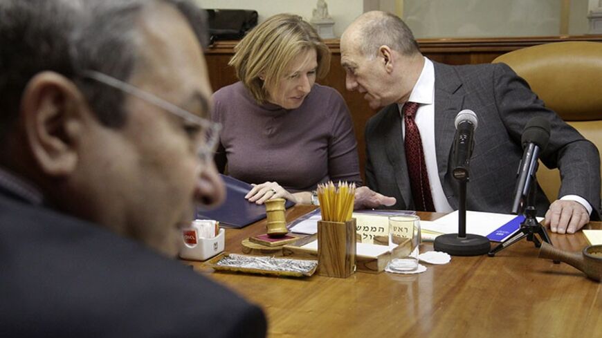 Israel's Defence Minister Ehud Barak (L) sits across from Prime Minister Ehud Olmert (R) and Foreign Minister Tzipi Livni during the weekly cabinet meeting in Jerusalem February 15, 2009. REUTERS/Emil Salman/JINI/Pool (JERUSALEM) - RTXBNIE