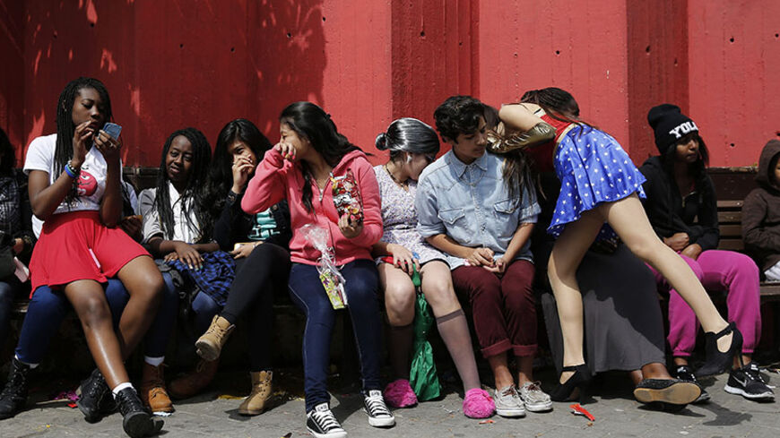 Youths sit on a bench after a parade for the Jewish holiday of Purim at the Bialik Rogozin school in south Tel Aviv March 14, 2014. At Bialik Rogozin, children of migrant workers and refugees are educated alongside native Israelis. Purim is a celebration of the Jews' salvation from genocide in ancient Persia, as recounted in the Book of Esther. REUTERS/Finbarr O'Reilly (ISRAEL - Tags: RELIGION SOCIETY) - RTR3H3KV