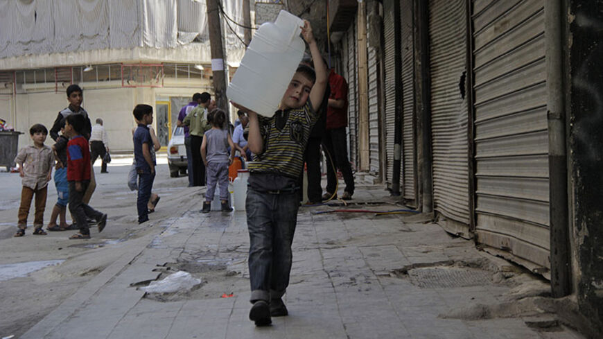 A boy carries a water container filled with water sourced from underground wells in Aleppo May 10, 2014. Activists say the water supply in the area has been cut off for more than a week. REUTERS/Aref Haj Youssef (SYRIA - Tags: POLITICS CIVIL UNREST CONFLICT SOCIETY) - RTR3OL64