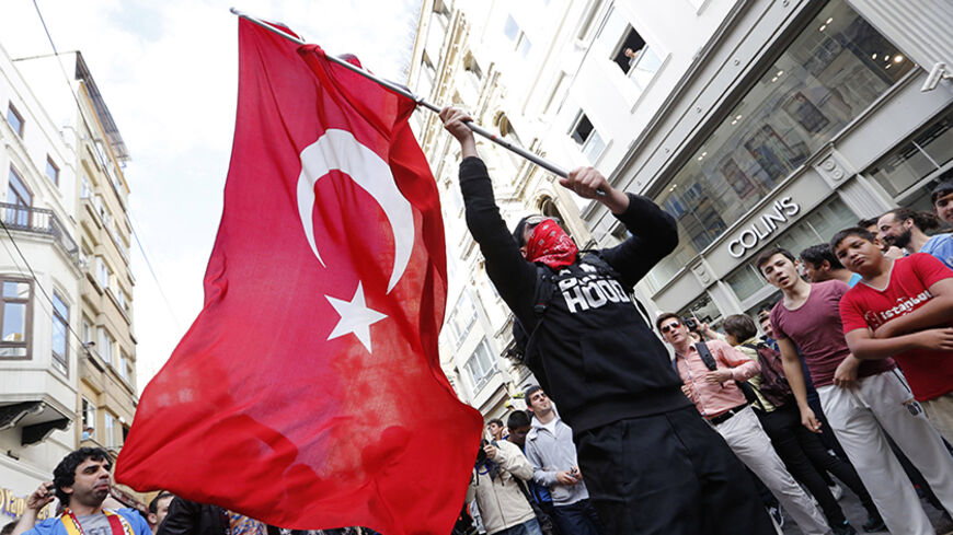 A masked demonstrator waves a Turkish flag during a protest in central Istanbul May 31, 2014. On the first anniversary of nationwide protests that shook Prime Minster Tayyip Erdogan's rule, barely a thousand anti-government demonstrators marched in Istanbul on Saturday. Outnumbered by riot police, they were soon sent scurrying into side streets by tear gas and water cannon. Their scant numbers were an illustration of Erdogan's tightening grip on power despite a year punctuated by street protests, internatio