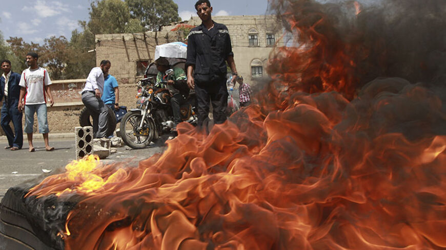 Protesters burn tyres during a demonstration against Yemen's fuel shortages in Sanaa June 11, 2014. Hundreds of protesters gathered outside the Yemeni president's house in the capital Sanaa on Wednesday to call for the fall of the government, angry at a city-wide power cut about to enter its third day and severe petrol shortages.  REUTERS/Mohamed al-Sayaghi (YEMEN - Tags: CIVIL UNREST POLITICS BUSINESS) - RTR3T7U4