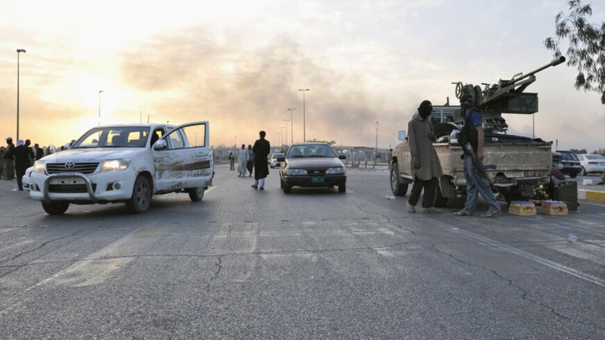 Fighters of the Islamic State of Iraq and the Levant (ISIL) stand guard at a checkpoint in the northern Iraq city of Mosul, June 11, 2014. Since Tuesday, black clad ISIL fighters have seized Iraq's second biggest city Mosul and Tikrit, home town of former dictator Saddam Hussein, as well as other towns and cities north of Baghdad. They continued their lightning advance on Thursday, moving into towns just an hour's drive from the capital. Picture taken June 11, 2014. REUTERS/Stringer (IRAQ - Tags: CIVIL UNRE