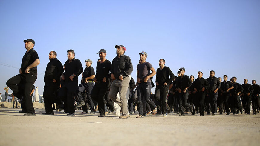 Mehdi Army fighters loyal to Shi'ite cleric Moqtada al-Sadr march during a military-style training in the holy city of Najaf, June 16, 2014. The United States said it could launch air strikes and act jointly with its arch-enemy Iran to support the Iraqi government, after a rampage by Sunni Islamist insurgents across Iraq that has scrambled alliances in the Middle East. REUTERS/Ahmad Mousa (IRAQ - Tags: CIVIL UNREST POLITICS) - RTR3U41A