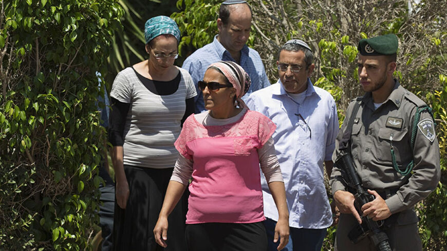Iris and Uri Yifrah (foreground), Bat-Galim Shaer (back L), and Avi Fraenkel (back R), the respective parents of missing Israeli teens Eyal, Gil-Ad and Naftali, walk outside the Shaer family home in the West Bank Jewish settlement of Talmon June 23, 2014. Israel's army said it detained another 37 Palestinians overnight as it searched for the three missing teenagers and extended a crackdown on the Hamas Islamist group it accuses of kidnapping them. REUTERS/Finbarr O'Reilly (WEST BANK - Tags: CIVIL UNREST POL