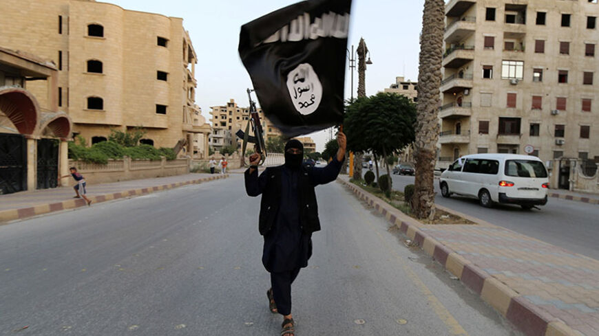 A member loyal to the Islamic State in Iraq and the Levant (ISIL) waves an ISIL flag in Raqqa June 29, 2014. The offshoot of al Qaeda which has captured swathes of territory in Iraq and Syria has declared itself an Islamic "Caliphate" and called on factions worldwide to pledge their allegiance, a statement posted on jihadist websites said on Sunday. The group, previously known as the Islamic State in Iraq and the Levant (ISIL), also known as ISIS, has renamed itself "Islamic State" and proclaimed its leader