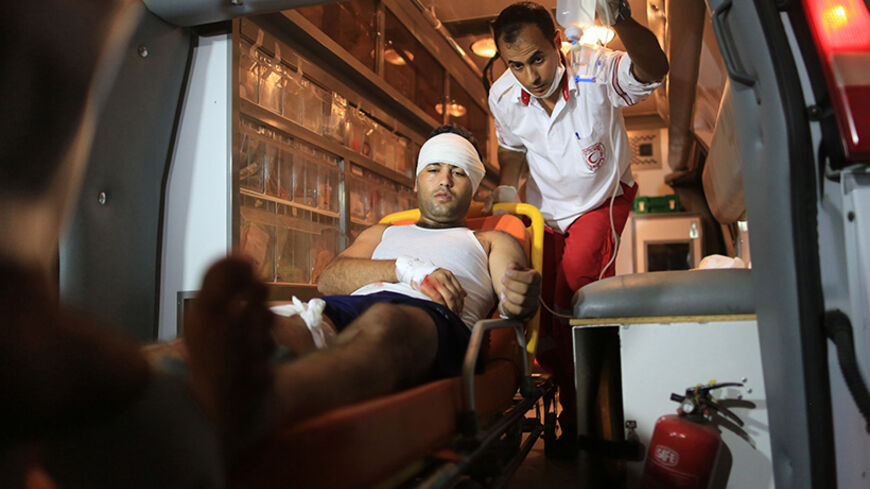 Medics treat a man, whom they said was wounded in an Israeli air strike, at a hospital in Gaza City on July 8, 2014. BY Wissam Nassar.