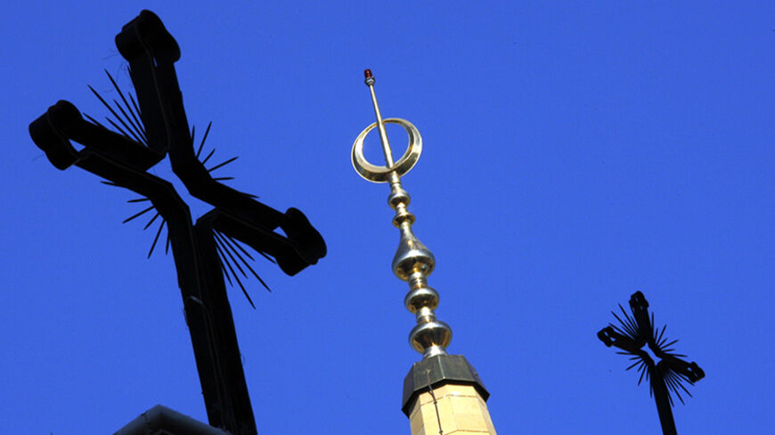 The Christian crosses of a Beirut cathedral surround a minaret of al Amin mosque in Beirut November 28, 2006. REUTERS/Eric Gaillard (LEBANON) - RTR1JSZR
