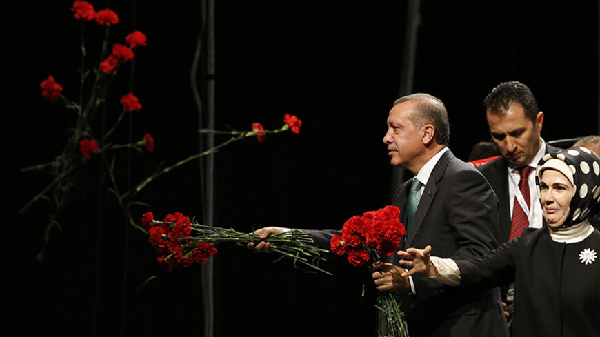 Turkish Prime Minister Tayyip Erdogan throws flowers to his supporters next to his wife Emine during his visit in Cologne May 24, 2014.              REUTERS/Wolfgang Rattay (GERMANY - Tags: POLITICS TPX IMAGES OF THE DAY) - RTR3QOHJ