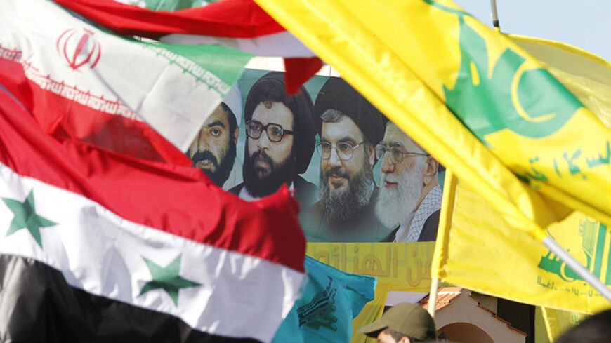 A poster of (R-L) Iran's supreme leader Ayatollah Ali Khamenei, Hezbollah Secretary-General Sayyed Hassan Nasrallah, former Hezbollah Secretary-General Sayyed Abbas al-Musawi and Lebanese resistance leader and cleric Sheikh Ragheb Harb, is seen in between Iranian, Syrian, Lebanese and Hezbollah flags during Resistance and Liberation Day celebrations in Bint Jbeil May 25, 2014. The event commemorates the 14th anniversary of Israel's withdrawal from southern Lebanon.  REUTERS/Ali Hashisho (LEBANON - Tags: POL