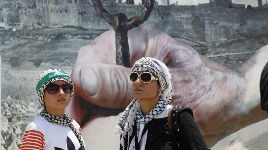 Women stand in front of a poster depicting al-Aqsa mosque and the Dome of the Rock during a protest organised by the Jordanian Islamic Action Front in Swaymeh, at the Dead Sea area near the border between Jordan and Israel June 6, 2014. The protest is part of the Global March to Jerusalem initiative, marking the 47th anniversary of Israel's capture of East Jerusalem in the 1967 Middle East war. REUTERS/Majed Jaber (JORDAN  - Tags: POLITICS CIVIL UNREST ANNIVERSARY) - RTR3SK3K