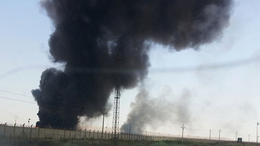 Smoke rises from a oil refinery in Baiji, north of Baghdad, in this picture taken through the windscreen of a car, June 19, 2014. Iraqi government forces battled Sunni rebels for control of the country's biggest refinery on Thursday as Prime Minister Nuri al-Maliki waited for a U.S. response to an appeal for air strikes to beat back the threat to Baghdad. Secretary of State John Kerry said President Barack Obama still had "all options" open to him but U.S. regional allies Turkey and Saudi Arabia echoed conc