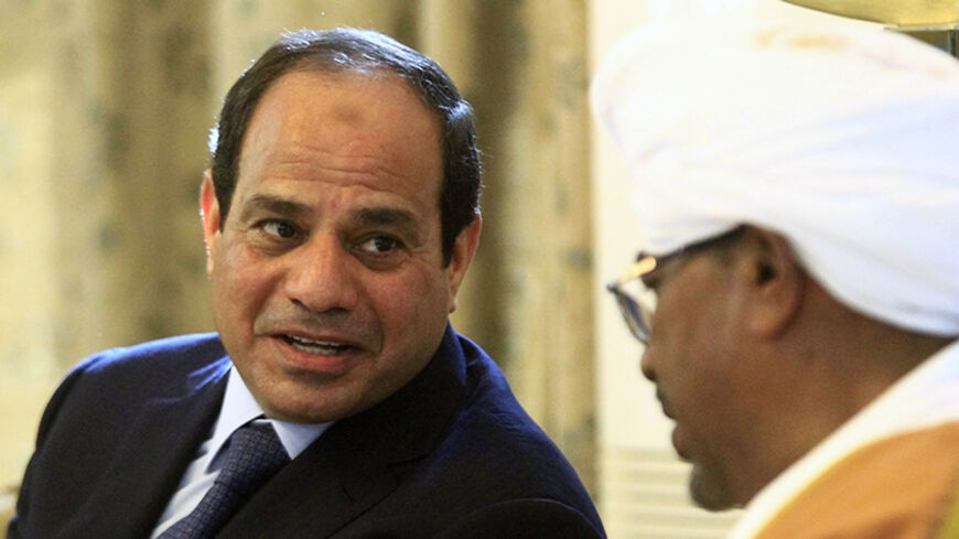 Egypt's President Abdel Fattah al-Sisi (L) talks to Sudan's President Omar al-Bashir at Khartoum International Airport in Khartoum June 27, 2014. REUTERS/Mohamed Nureldin Abdallah (SUDAN - Tags: POLITICS) - RTR3W4LF