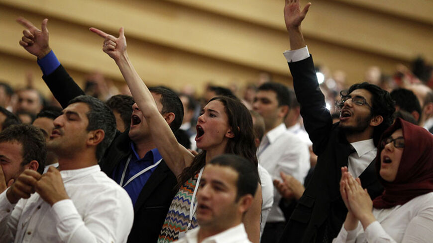 Supporters of Turkey's Prime Minister Tayyip Erdogan cheer as he declares his candidacy in Ankara July 1, 2014. Erdogan declared his candidacy on Tuesday for a more powerful presidency which rivals fear may entrench authoritarian rule and supporters, especially conservative Muslims, see as the crowning prize in his drive to reshape NATO member Turkey. REUTERS/Umit Bektas (TURKEY - Tags: POLITICS ELECTIONS) - RTR3WLVO
