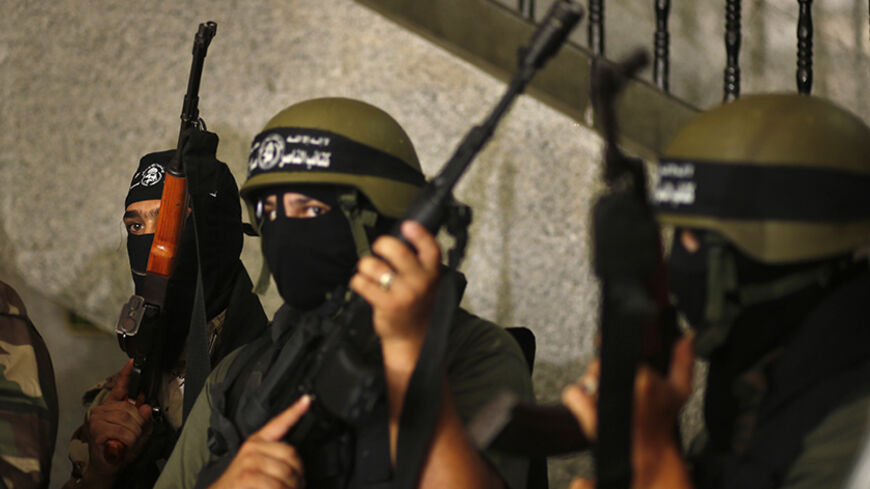 Palestinian militants of al-Nasser Brigades hold weapons during a news conference on cross-border escalation between Palestinians and Israel, in Gaza City July 5, 2014. With Israel having mobilised ground forces outside Gaza on Thursday in a threat to invade, Egypt tried to mediate a truce. Israel and the Islamist Palestinian Hamas movement each said the other had to back down first. REUTERS/Mohammed Salem (GAZA - Tags: POLITICS CIVIL UNREST) - RTR3X7MR