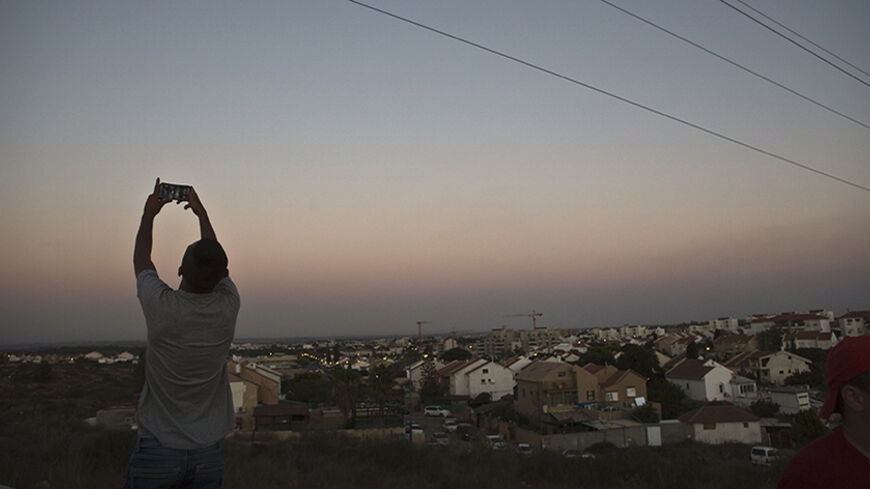 An Israeli teen takes a selfie, with the Gaza Strip on his background, on a hill near Sderot, opposite the northern Gaza Strip July 13, 2014. Thousands fled their homes in a Gaza town on Sunday after Israel warned them to leave ahead of threatened attacks on rocket-launching sites, on the sixth day of an offensive that Palestinian officials said has killed at least 160 people. Militants in the Hamas-ruled Gaza Strip kept up rockets salvoes deep into the Jewish state and the worst bout of Israel-Palestinian 