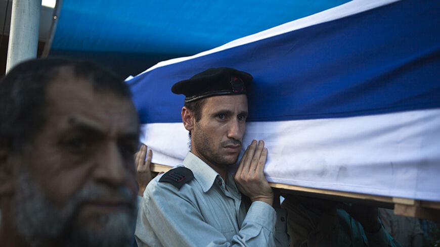 An Israeli soldier carries the flag-draped coffin of his fallen comrade Natan Cohen, killed during fighting in Gaza on Tuesday, during his funeral in Modi'in, a town between Jerusalem and Tel Aviv, July 23, 2014. Gaza fighting raged on Wednesday, displacing thousands more Palestinians in the battered territory as U.S. Secretary of State John Kerry said efforts to secure a truce between Israel and Hamas had made some progress. Israel launched its offensive on July 8 to halt rocket salvoes by Hamas and its al