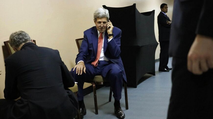 U.S. Secretary of State John Kerry (C), surrounded by aides, sits in the service hallway of a hotel in Cairo July 25, 2014, as he speaks on the phone with Qatar's Foreign Minister Khaled al-Attiyah about the terms of a ceasefire in Israel's fight against Islamist militants in Gaza, during a break in his meetings with Egypt's Foreign Minister Sameh Shukri and U.N. Secretary-General Ban Ki-moon. Kerry said on Friday that there are still disagreements on the terminology for a Gaza truce but he is confident the