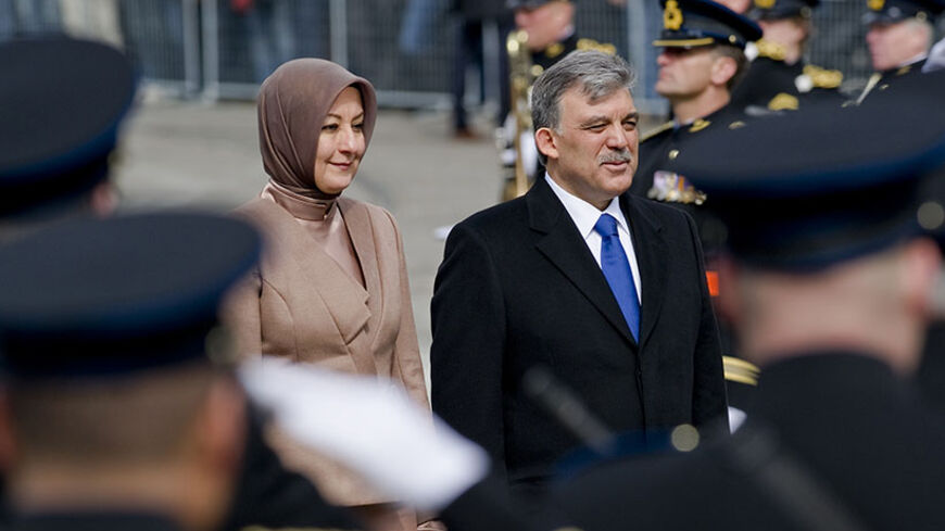 Turkey's President Abdullah Gul (R) and his wife Hayrunnisa Gul walk over the Dam Square to attend a wreath laying ceremony in Amsterdam April 17, 2012. Gul is in the Netherlands for a three-day state visit. REUTERS/Robin van Lonkhuijsen/United Photos (NETHERLANDS - Tags: POLITICS) - RTR30U9Y