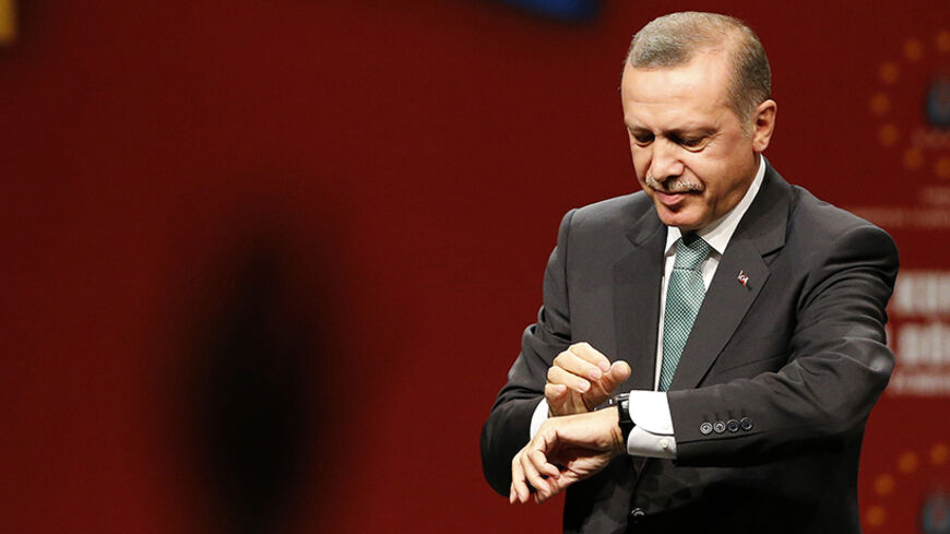 Turkish Prime Minister Tayyip Erdogan looks at his watch at the end of his meeting with supporters during his visit in Cologne May 24, 2014.                 REUTERS/Wolfgang Rattay   (GERMANY - Tags: POLITICS) - RTR3QOIL