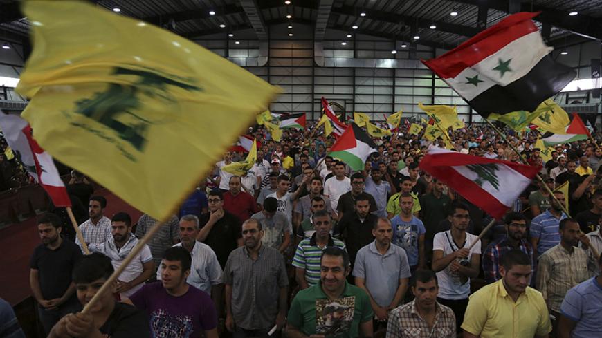 Hezbollah supporters wave Lebanese, Syrian, Palestinian and Hezbollah flags as they listen to their leader Sayyed Hassan Nasrallah addressing his supporters during a rally to mark "Quds (Jerusalem) Day" in Beirut's southern suburbs July 25, 2014. REUTERS/Sharif Karim    (LEBANON - Tags: POLITICS CIVIL UNREST RELIGION) - RTR4056R