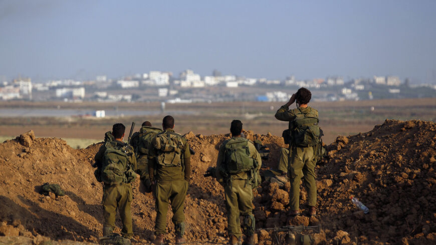 Israeli soldiers look towards Gaza from Israel August 3, 2014. The fighting on Sunday pushed the Gaza death toll given by Palestinian officials to 1,726, most of them civilians. Israel has confirmed that 64 soldiers have died in combat, while Palestinian rockets have also killed three civilians in Israel. Israel began its air and naval offensive against Gaza on July 8 following a surge of cross-border rocket salvoes by Hamas and other guerrillas, later escalating the operation into ground incursions.     RE