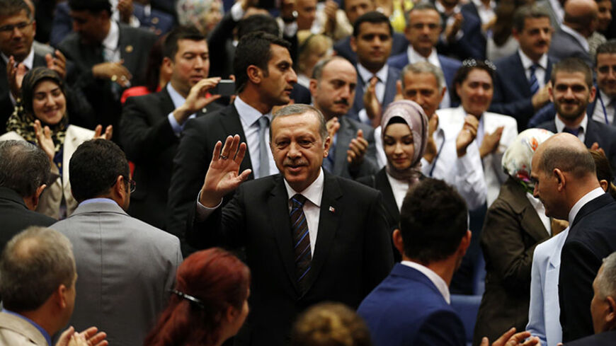 Turkey's Prime Minister Tayyip Erdogan greets members of his ruling AK Party (AKP) as he arrives at a meeting at the party headquarters in Ankara August 14, 2014. Turkish president-elect Erdogan urged his ruling AK Party on Thursday to work for a stronger parliamentary majority next year to enable them to re-write the constitution, signalling no let-up in his drive to create an executive presidency. REUTERS/Umit Bektas (TURKEY - Tags: POLITICS) - RTR42E72