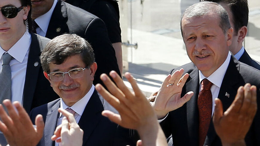 Turkey's Prime Minister Tayyip Erdogan (R) and Foreign Minister Ahmet Davutoglu greet their supporters as they leave Friday prayers in Ankara August 22, 2014. Erdogan, who will be sworn in as president next Thursday, named Davutoglu as his future prime minister on Thursday and vowed a power struggle against a U.S.-based cleric he accuses of plotting against him would continue. REUTERS/Umit Bektas (TURKEY - Tags: POLITICS) - RTR43CQ9