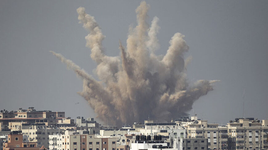 Smoke and sand are seen following what witnesses said was an Israeli air strike in Gaza August 25, 2014. Israel's Prime Minister Benjamin Netanyahu warned Palestinian civilians on Sunday to leave immediately any site where militants are operating, one day after Israel flattened a 13-storey apartment block in Gaza. Palestinian health officials say 2,115 people, most of them civilians and more than 400 of them children, have been killed in the Gaza Strip since July 8, when Israel launched an offensive with th