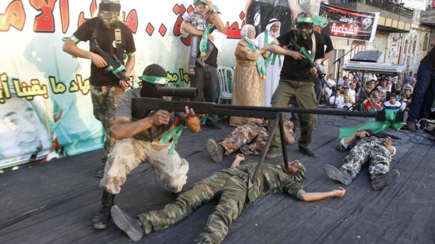 Palestinian Hamas supporters enact a scene simulating the killing of Israeli soldiers by Hamas militants during a rally celebrating what organizers say was a victory by Palestinians in Gaza over Israel following a ceasefire, in the West Bank city of Nablus August 29, 2014. An open-ended ceasefire, mediated by Egypt, took effect on Tuesday evening. It called for an indefinite halt to hostilities, the immediate opening of Gaza's blockaded crossings with Israel and Egypt, and a widening of the territory's fish