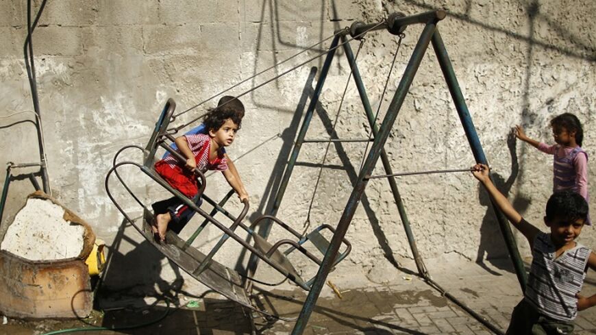 Palestinian children play on a swing in Jabaliya refugee camp in the northern Gaza Strip August 4, 2014. A seven-hour truce under which Israel would unilaterally hold fire in most of the Gaza Strip went into force on Monday and Palestinians immediately accused Israel of breaking the ceasefire by bombing a house in Gaza City. Gaza officials say 1,796 Palestinians, most of them civilians, have been killed and more than a quarter of the impoverished enclave's 1.8 million residents displaced. As many as 3,000 P