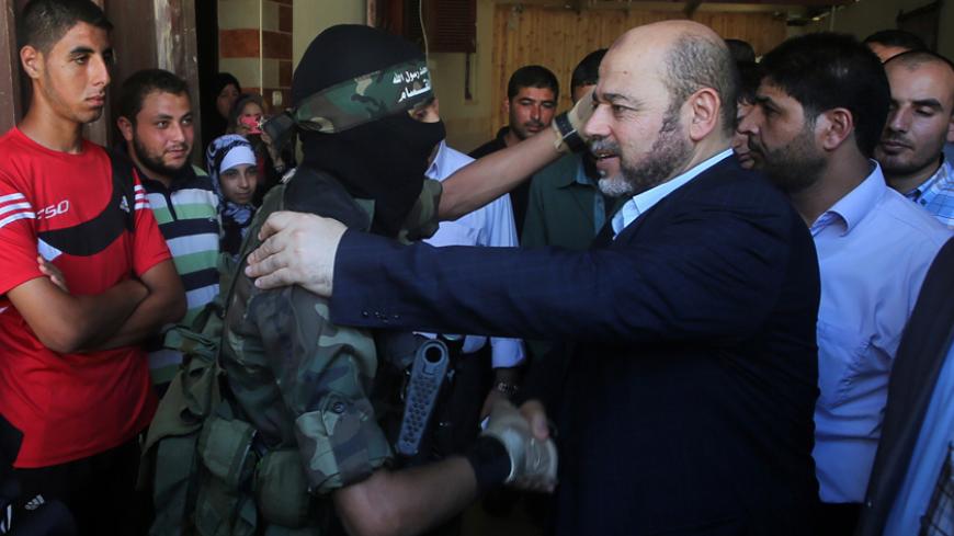 Deputy chairman of Hamas' political bureau Mussa Abu Marzuk (R) hugs a member of the Ezzedine al-Qassam Brigades, the Islamist movement's armed wing, as he visits relatives of killed senior Hamas commander Mohammed Abu Shamala on August 28, 2014 in Rafah in the southern of Gaza Strip. Shamala, a member of the Ezzedine al-Qassam Brigades, has been killed in the Gaza Strip by the Israeli warplanes on August 21, 2014. Millions in and around the war-torn coastal enclave were enjoying a second day of peace after