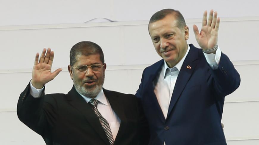 Turkey's Prime Minister and leader of ruling Justice and Development Party (AKP) Tayyip Erdogan (R) and his guest, Egypt's President Mohamed Mursi greet the audience during the AKP congress in Ankara September 30, 2012. REUTERS/Murad Sezer (TURKEY - Tags: POLITICS) - RTR38LZD
