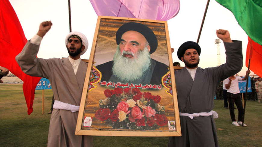 Shi'ite volunteers, who have joined the Iraqi army to fight against militants of the Islamic State, formerly known as the Islamic State in Iraq and the Levant (ISIL), carry a picture of Grand Ayatollah Ali Sistani during a graduation ceremony after completing their field training in Najaf, August 16, 2014. School is out, but northern Baghdad's classrooms are packed - not with students, but with people who have travelled further than most to escape the Sunni militant onslaught splitting Iraq. REUTERS/Alaa Al