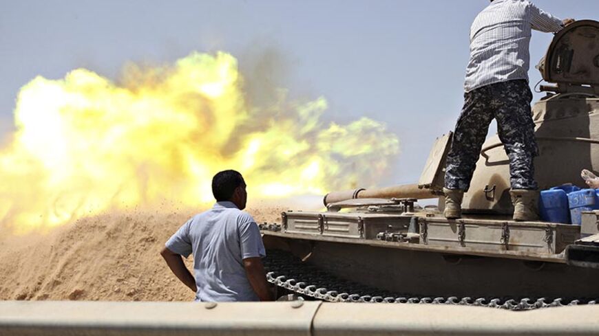 A tank belonging to the Western Shield, a branch of the Libya Shield forces, fires during a clash with rival militias around the former Libyan army camp, Camp 27, in the 27 district, west of Tripoli, August 22, 2014. REUTERS/Stringer (LIBYA - Tags: POLITICS CIVIL UNREST CONFLICT TPX IMAGES OF THE DAY) - RTR43F65